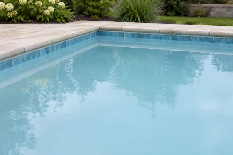 Cloudy blue water obscuring the floor of a backyard pool