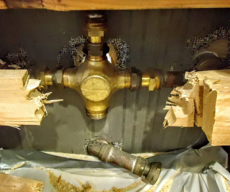 Exposed shower valve body and connected piping inside an open wall cavity