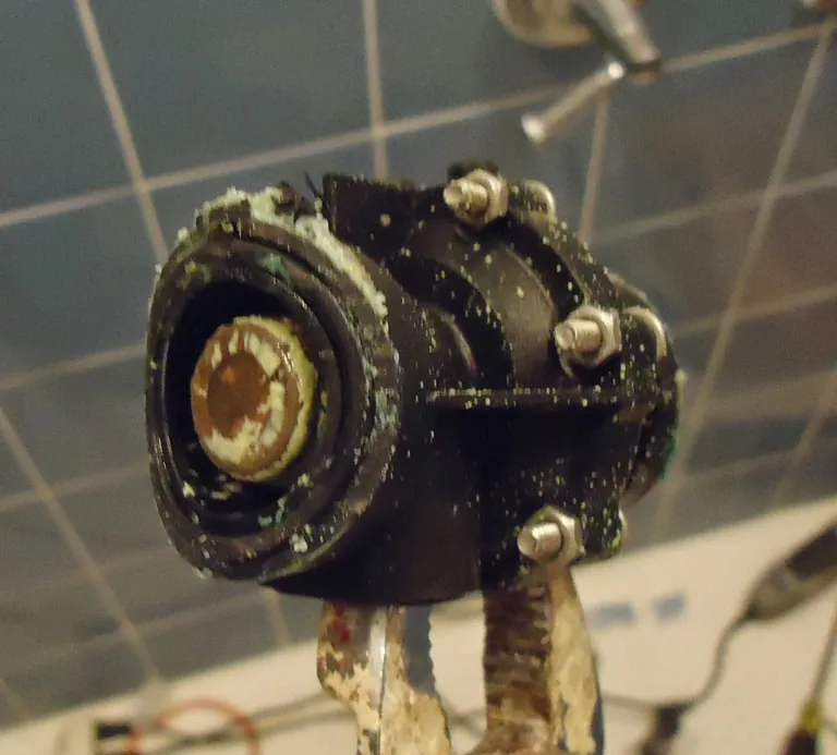 Close-up of a removed shower valve internal component with visible mineral buildup