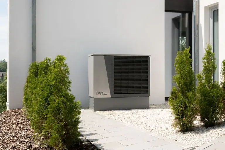 Outdoor air-source heat pump beside a home