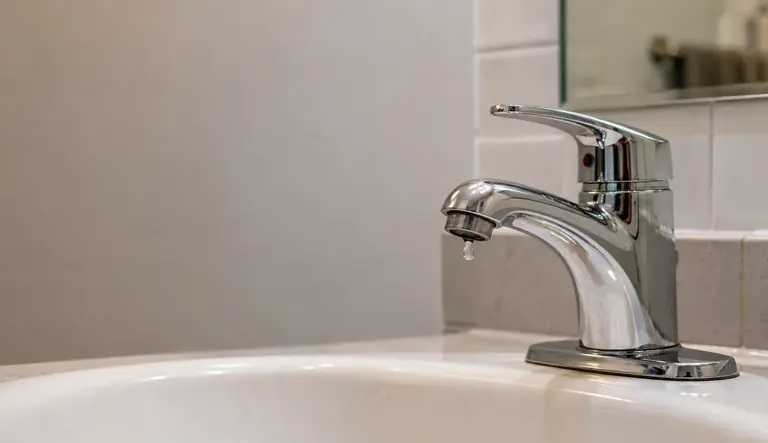 Chrome bathroom faucet above a white basin